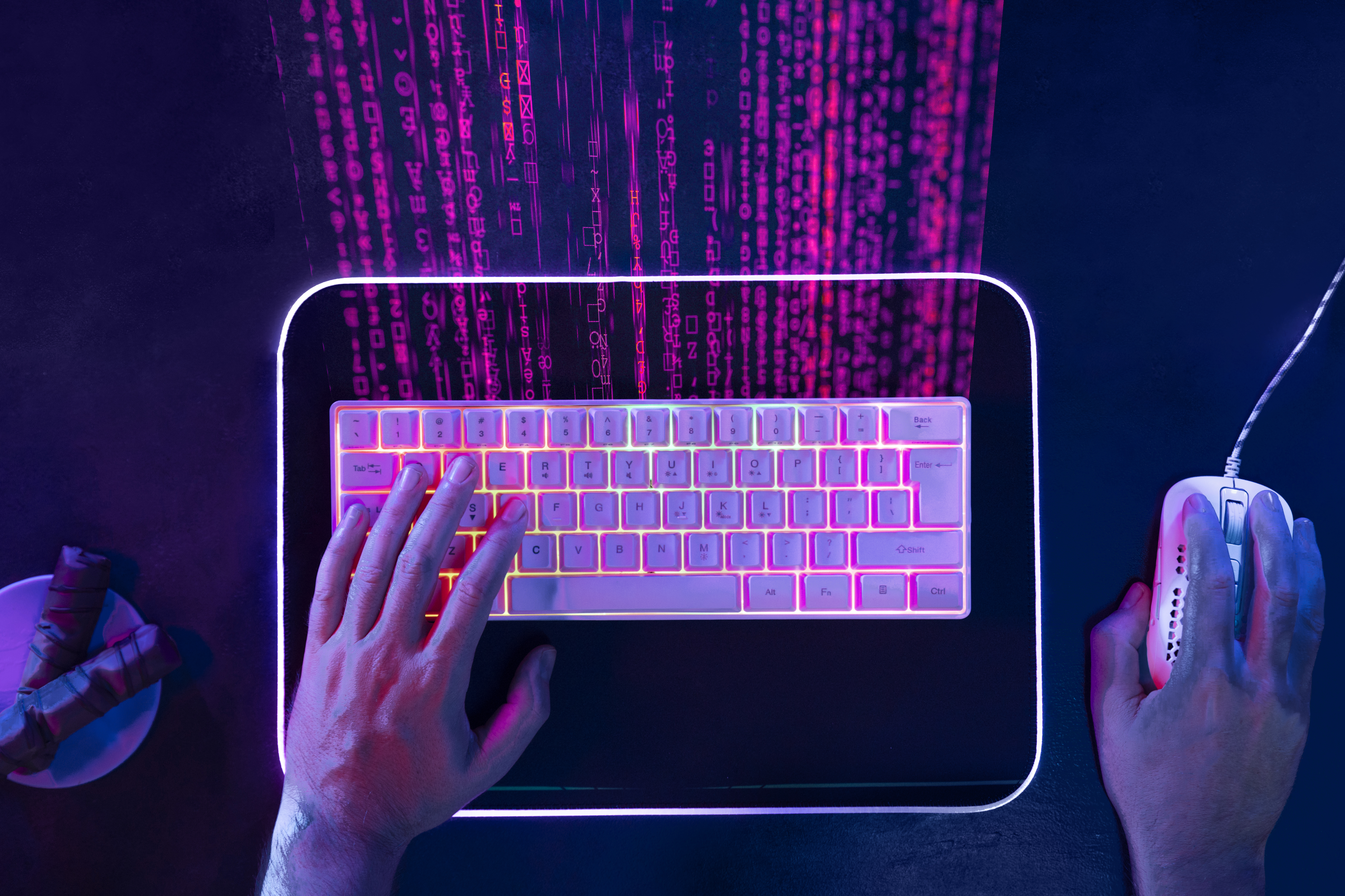 A developer working at a neon-lit keyboard while streams of code appear above the workstation.